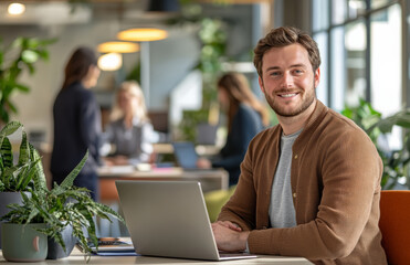 sales manager working on the laptop, colleagues in the background 