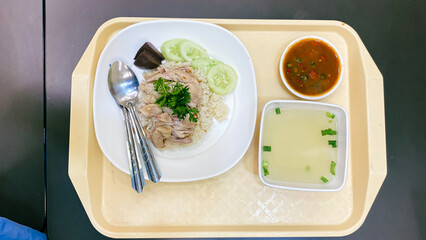 Steamed rice topped with chicken, dark soy sauce, and served with soup. Street food
