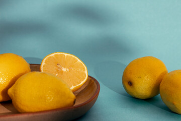 Fresh Lemons on Textured Fabric and blue background with Glass of Water