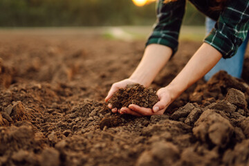 Female farmer hands holding black soil in their hands. Fertile land. garden field ground fertile concept.