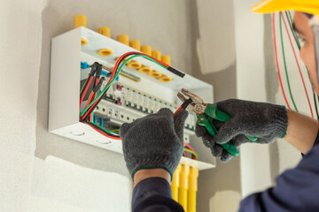 An electrician inspects the electrical wiring in an new home, upgrading the system to meet current safety standards.