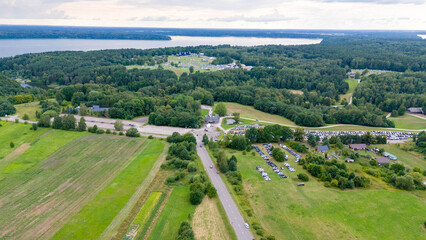 Drone photography of a town and music festival surrounded by forest during summer dusk