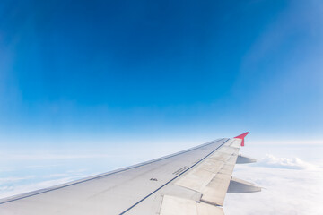 Obraz premium View from the airplane window at a beautiful cloudy sky and the airplane wing