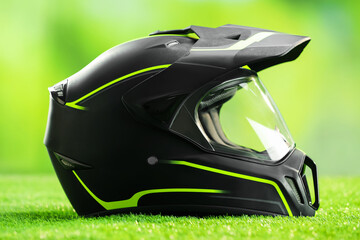 Modern motorcycle helmet with visor on green grass