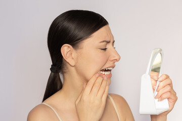 Young pretty caucasian woman suffering from gingivitis, gum inflammation. She looking at her red...