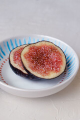 Beautiful fresh sliced black figs on white background