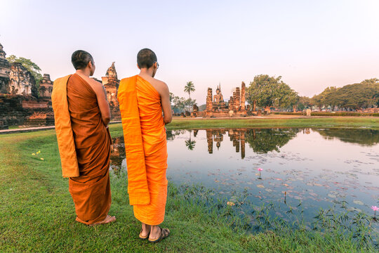 Buddhist monks looking at temple, Sukhothai, Thailand
