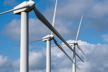 wind turbines against a blue sky, highlighting the sleek and modern design of these structures that silently convert wind into renewable energy for a greener future in Tarragona Spain