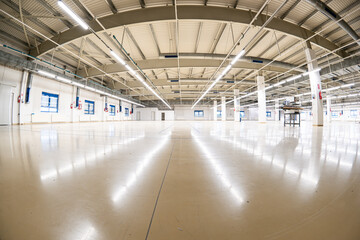 Closed down empty factory interior manufacturing hall with tall ceiling, concrete beams. Wide angle...