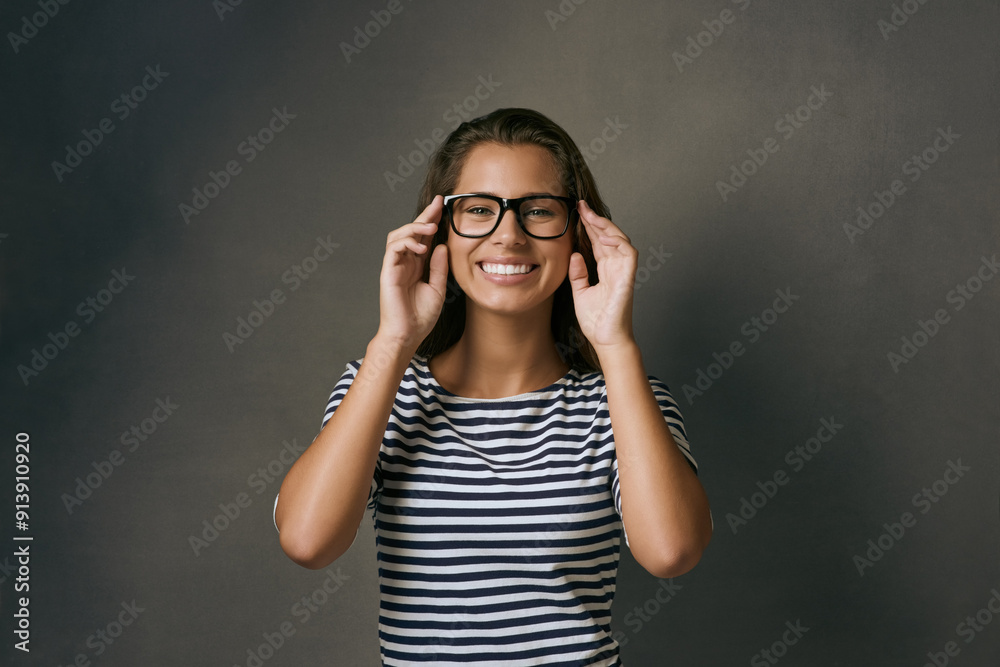 Wall mural Girl, portrait and smile with glasses in studio with prescription lens for eye care, optometry and healthcare. IT professional, confident and gray background with spectacles for vision and space.