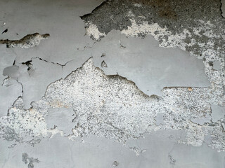 Grunge wall texture background. Paint cracking off dark wall with rust underneath