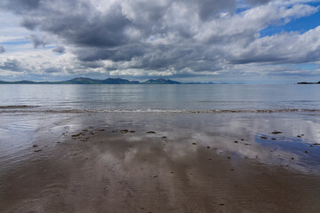 Dark clouds stream across Llanddwyn beach in Anglesey, Wales.