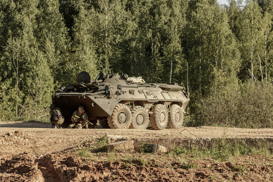 The gunmen are hiding behind the BTR-82A on the road in the forest. Russian AFV or APC.