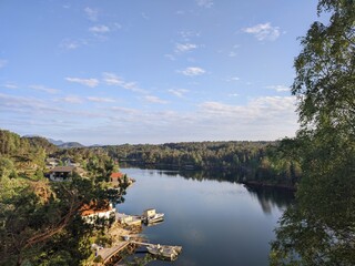 Enjoy a picturesque view of a serene lake landscape with clear blue skies and lush greenery