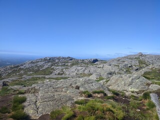 Experience the peaceful beauty of a mountain landscape under a clear blue sky with rugged terrain