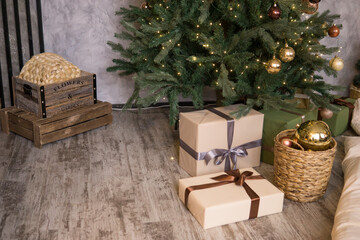 Bronze balls on the Christmas tree close-up. Gift boxes under the tree. The concept of celebrating New Year and Christmas