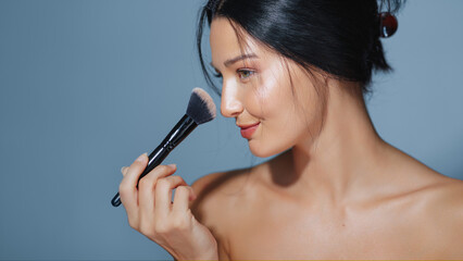 Beautiful Woman Applying Makeup with Brush and Natural Glow