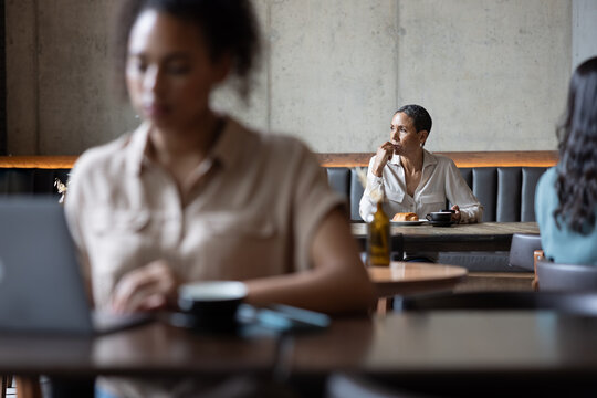 Senior woman looking out of the window in a cafe
