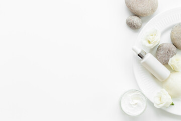 White roses and stones with skin care cosmetics products. Mock up, top view