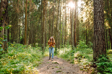 Obraz premium Young woman enjoys the forest view. Trips. Active lifestyle. Hiking.