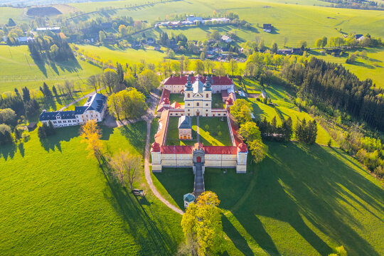 Hora Matky Bozi Monastery in Dolni Hedec near Kraliky, Czechia. It shows the monastery complex with its surrounding greenery and nearby village.