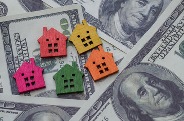 A house set against a backdrop of banknotes represents the financial considerations and investment potential in property ownership.