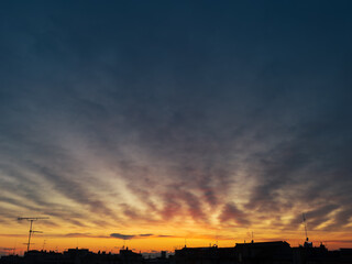 City sunset with golden clouds over the dark rooftops.