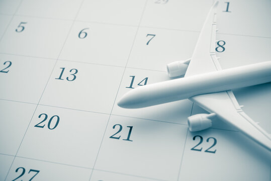 Airplane on white blank calendar copy space in monochrome. Travel trip reminder, annual leave travel period for relaxation concept. Period of paid time off (PTO) granted to employees by their employer