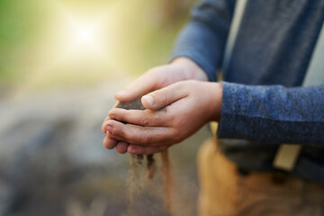 Child, hands and sand in garden outdoor with sensory play to explore environment, curious and development. Kid, person and playful with soil for earth day, creative activity and fun game in nature