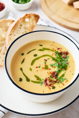 Bowl of potato soup with parsley and bacon with toasted bread croutons in white bowl. Comfort meal