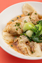 Portion of appetizing asian wonton dumplings with bok choi
