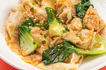 Portion of appetizing asian wonton dumplings with bok choi