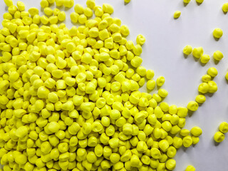 Neon yellow masterbatch granules on white background.Color pigment carrier polymer in plastic...