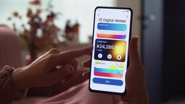 Paying online with a credit card using digital wallet on the smartphone. Choosing from different credit cards for contactless payment. Fictional Interface.
