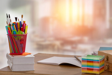 School accessories and stationery and books on wooden school desk with copy space. Blurred...