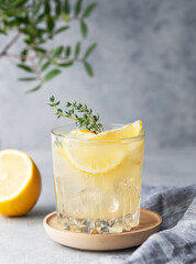 Lemonade drink with fresh lemon, mint and ice. Refreshing citrus mojito cocktail on a light background with napkin