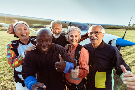 Diverse senior people taking group selfie before skydiving