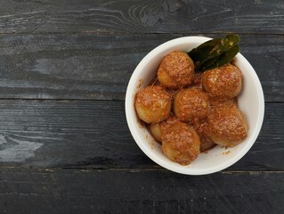 Indonesian food cilok bumbu kacang is a food made from flour and sago with peanut sauce on the wooden table