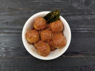 fried chicken nuggetsIndonesian food cilok bumbu kacang is a food made from flour and sago with peanut sauce on the wooden table