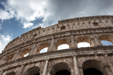 Wall of stone making up the Roman Colosseum on a cloudy day
