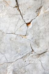 Fototapeta premium Close-up of a cracked concrete wall showing detailed textures and patterns, ideal for backgrounds and design elements.