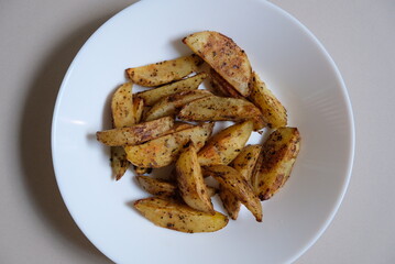 Baked wedges potato on a white plate.