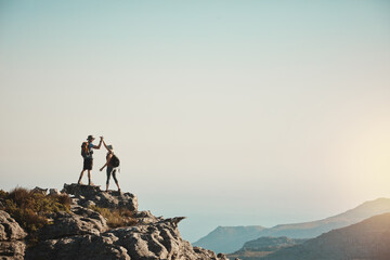 Hiking, high five and couple on mountain with sky for adventure, cliff trekking and fitness. Travel, nature and people for mockup space and exercise achievement on holiday, journey or vacation