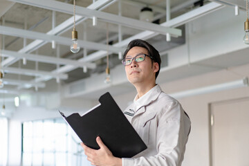 クリップボードを持つ作業員の男性