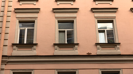 A lovely pink building that features a few windows on its facade