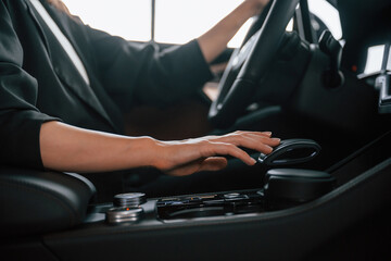 Close up view of woman hands that are driving new car