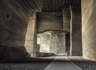 The Fertőr&aacute;kosi Quarry in Hungary presents an impressive view with its towering stone walls and central walkway that guides visitors through this historic limestone extraction site.