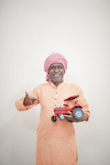 Indian farmer, equipped with a miniature tractor toy