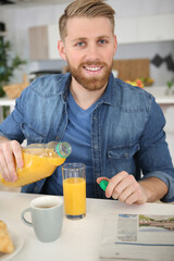 man drinking orange juice at breakfast