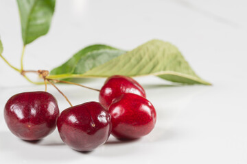 Fresh dark sweet cherries on white marble